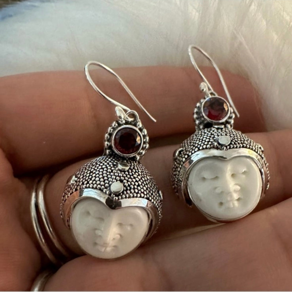 Hand-crafted 925 sterling silver Balinese carved bone face earrings with faceted/cut Garnet gemstones